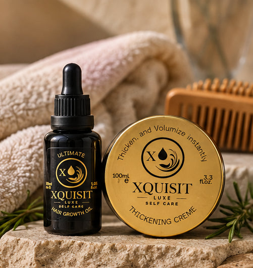 Xquisit 30ml hair oil and 100ml thickening cream beside a towel, wooden brush and rosemary sprigs.