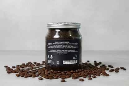 Xquisit Luxe coffee body scrub jar with a black label on a gray surface