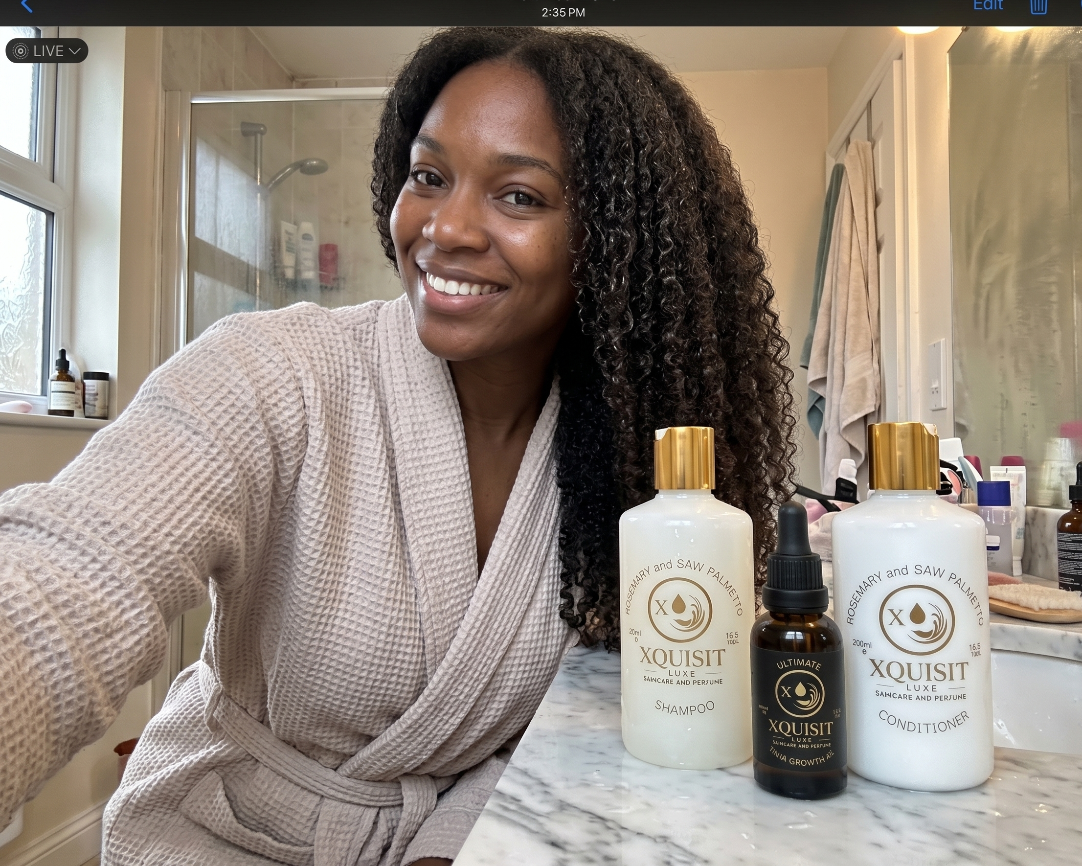 Woman in a robe with Xquisit skincare products on a bathroom counter.